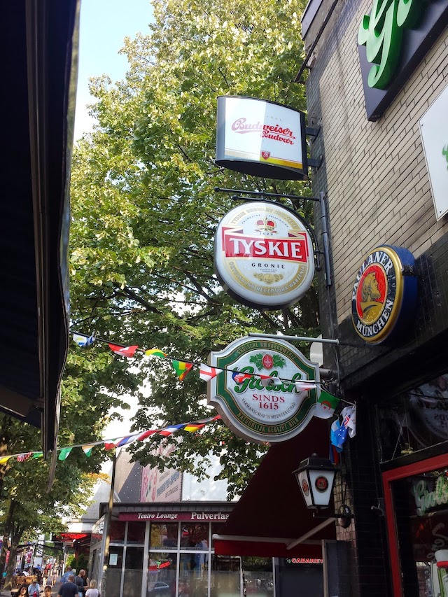 Beer advertisements on a pub building. Featured brands: Budweiser, Tyskie, Grolsch and Paulaner.